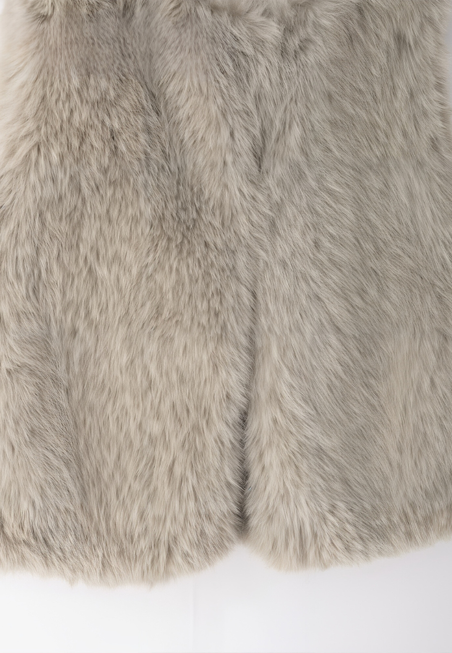 A stylish woman wearing a fluffy vest paired with a turtleneck top and a skirt, showcasing the elegant design and cozy texture of the Ava Women's Fluffy Vest, ideal for layering in chic outfits.