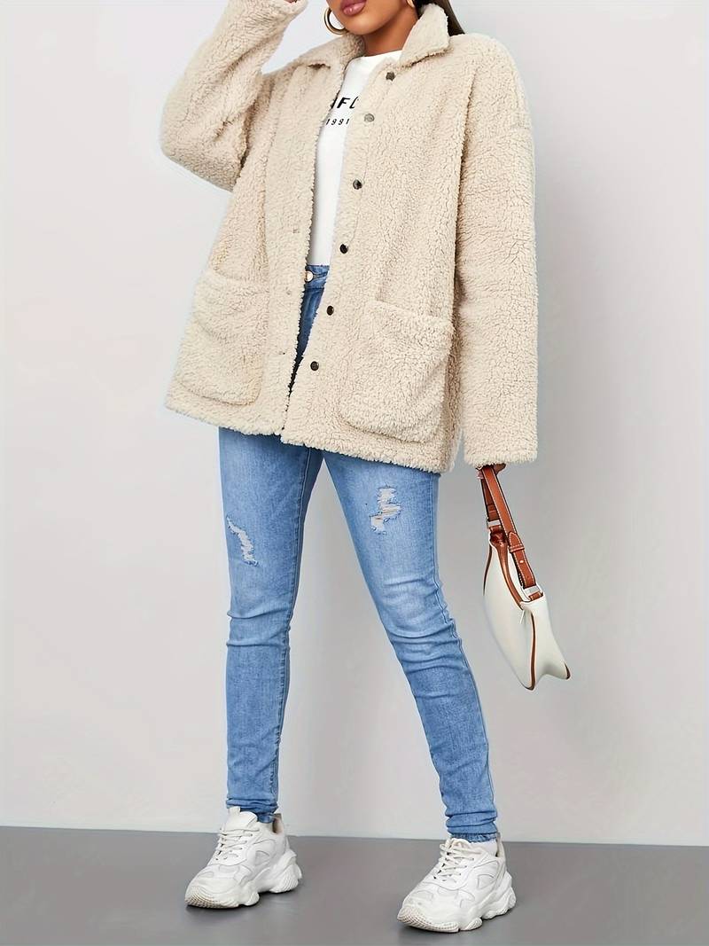 A stylish women's sherpa jacket with a cozy oversized fit, featuring button closures, large front pockets, and a soft textured design, paired with casual jeans and a printed t-shirt for a trendy look.