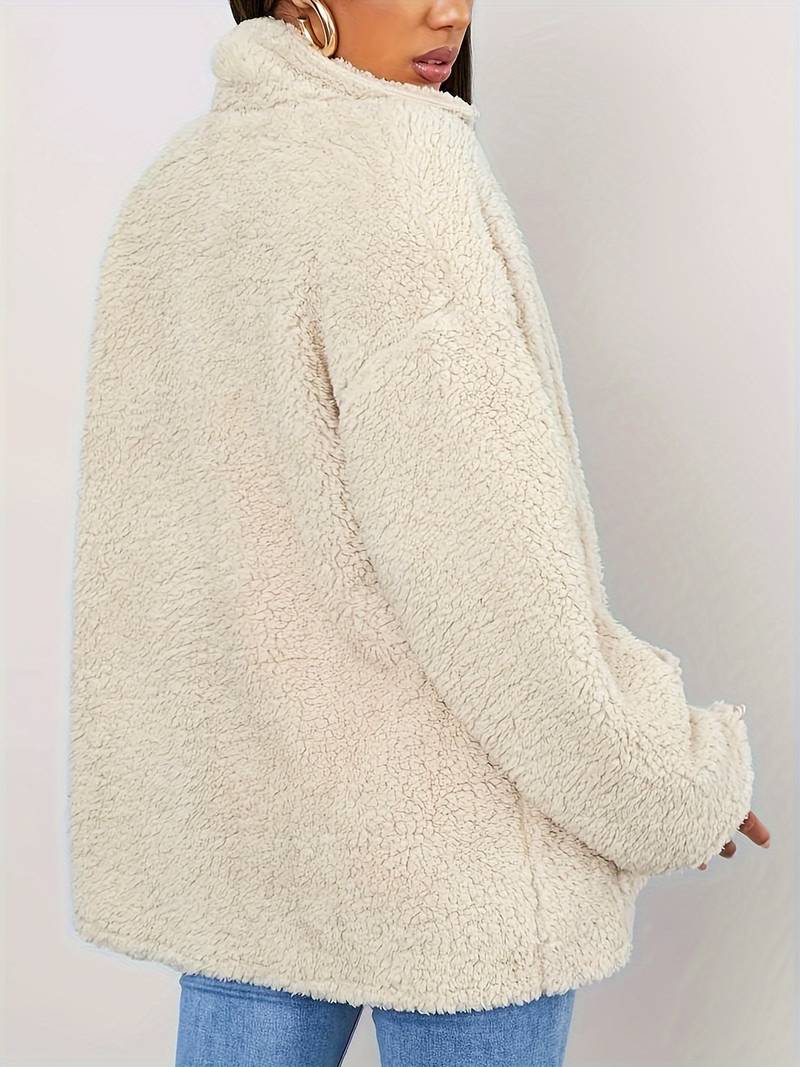 A stylish women's sherpa jacket with a cozy oversized fit, featuring button closures, large front pockets, and a soft textured design, paired with casual jeans and a printed t-shirt for a trendy look.