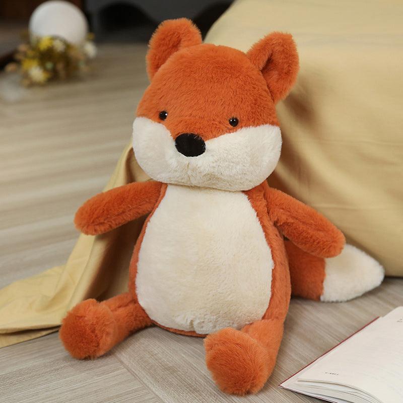 Plush toy set featuring a family of foxes in various sizes, arranged on a cozy bed in a warm and inviting room setting.