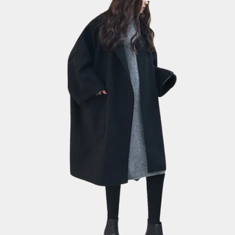 Stylish oversized women's coat with a relaxed fit, featuring deep pockets and a cozy design, worn by a model holding a cup while walking gracefully.