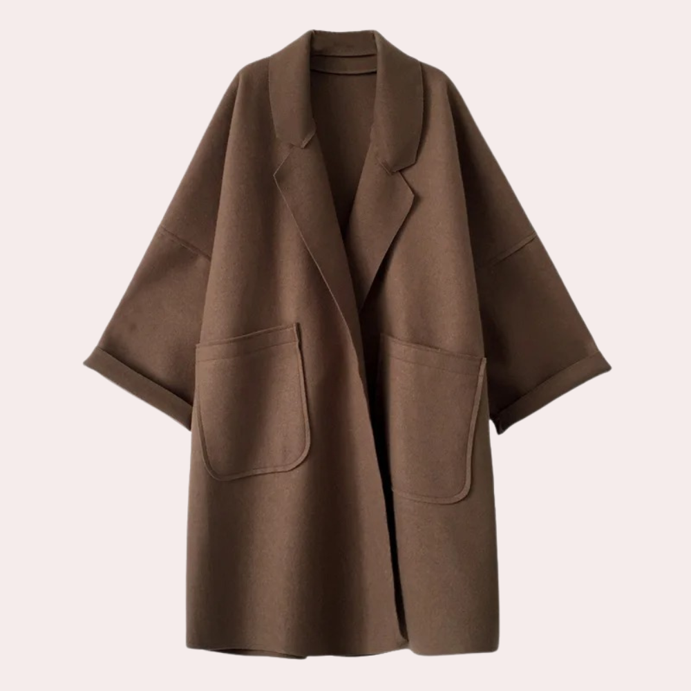 Stylish oversized women's coat with a relaxed fit, featuring deep pockets and a cozy design, worn by a model holding a cup while walking gracefully.