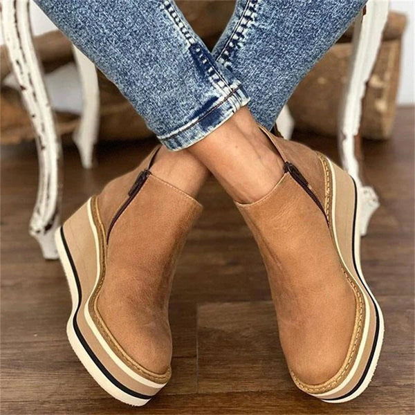 Stylish women's ankle boots with a modern design and zipper closure, displayed on a wooden floor. Perfect for casual or everyday wear.