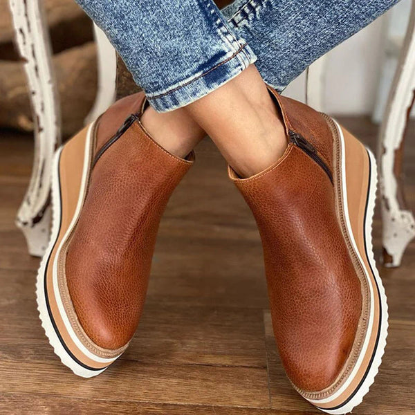 Stylish women's ankle boots with a modern design and zipper closure, displayed on a wooden floor. Perfect for casual or everyday wear.
