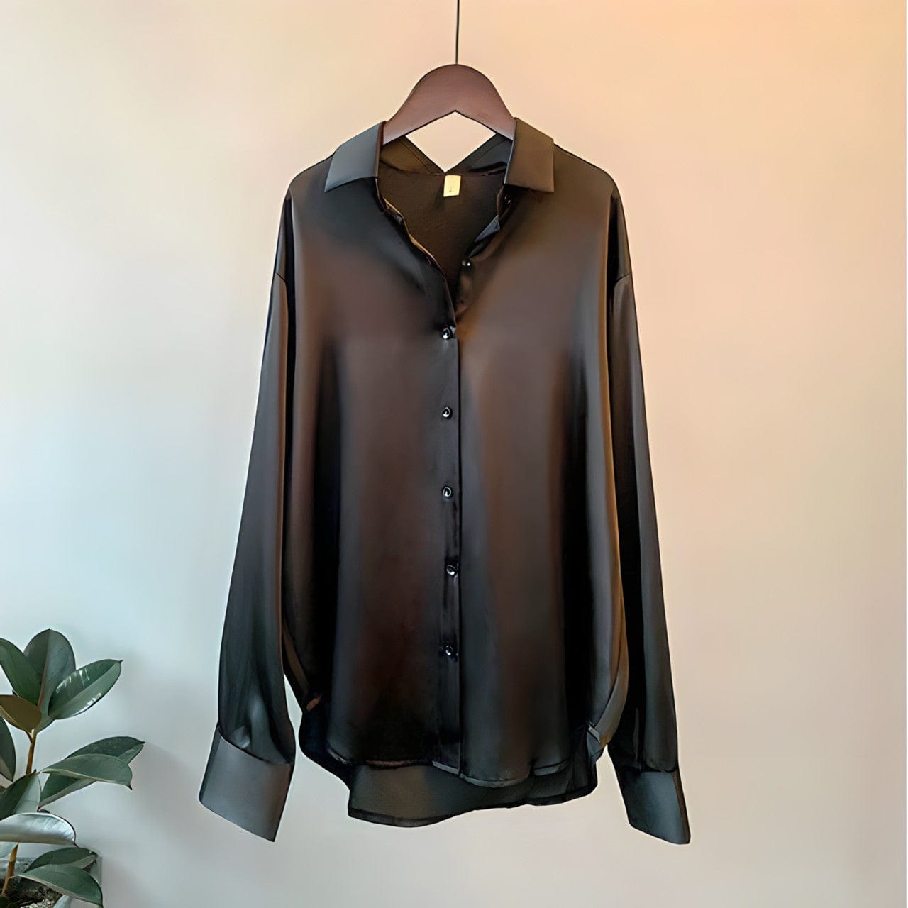 A stylish women's flowing button-up shirt with an elegant design, featuring a relaxed fit and sleek details, perfect for office wear or casual outings.
