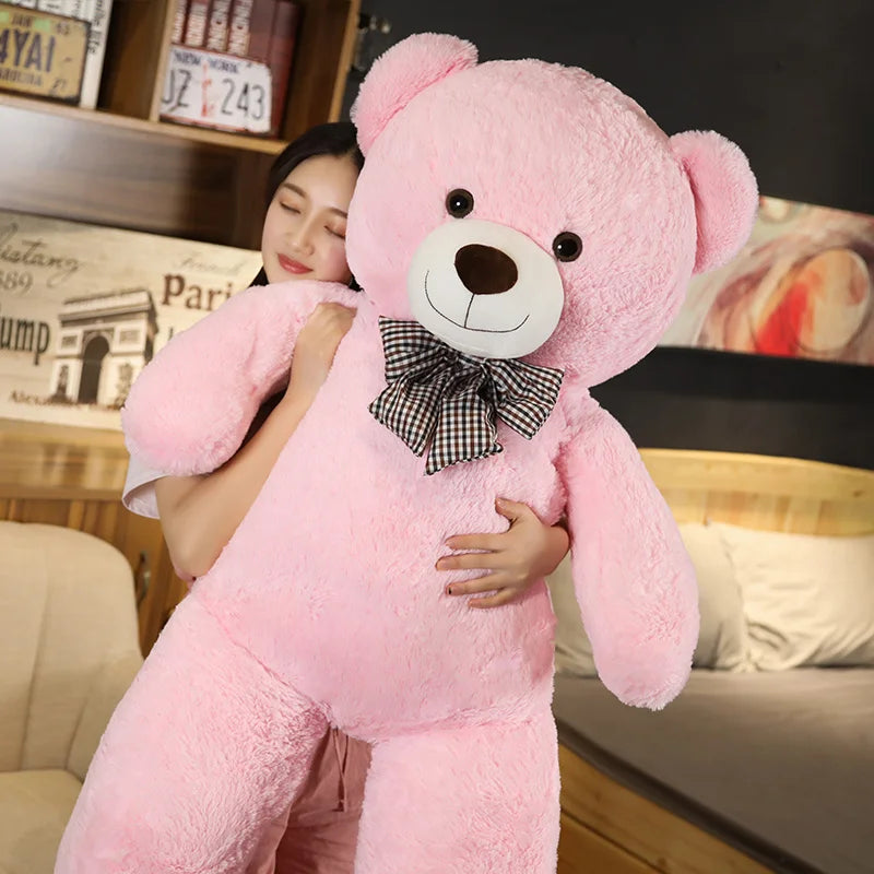 A giant plush bear with a huggable design, featuring soft fabric and an adorable bow, perfect for cuddles, decoration, or as a thoughtful gift for all ages.