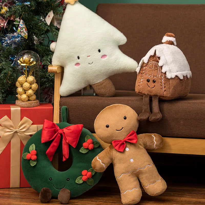 Festive plush toy set featuring a Christmas tree, gingerbread house, wreath, and gingerbread figure, displayed in a cozy holiday-themed setting with wrapped gifts and decorations.
