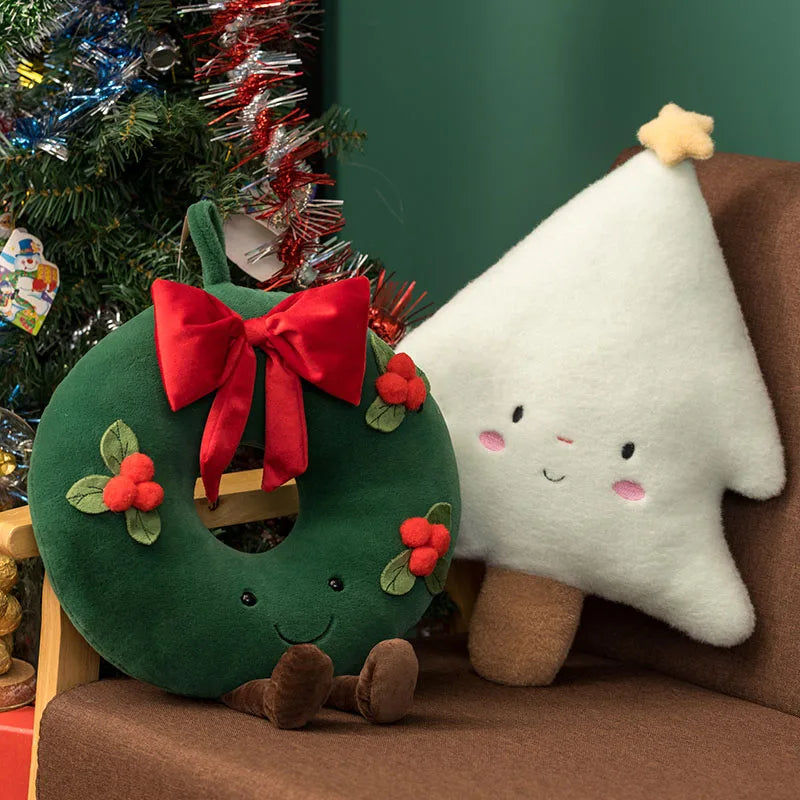 Festive plush toy set featuring a Christmas tree, gingerbread house, wreath, and gingerbread figure, displayed in a cozy holiday-themed setting with wrapped gifts and decorations.