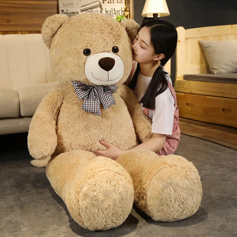 A giant plush bear with a huggable design, featuring soft fabric and an adorable bow, perfect for cuddles, decoration, or as a thoughtful gift for all ages.