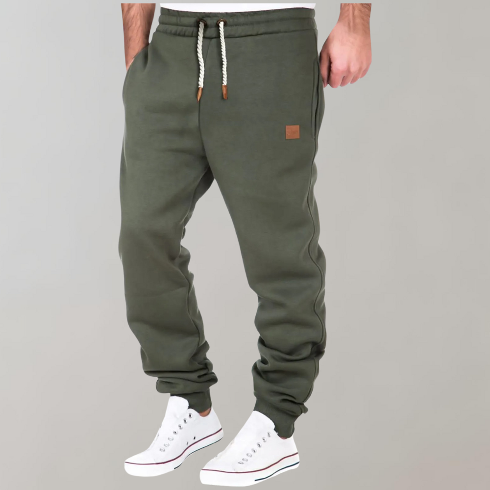 A pair of men's joggers with a relaxed fit, featuring an adjustable drawstring waistband, practical pockets, and a modern design, styled with casual sneakers.