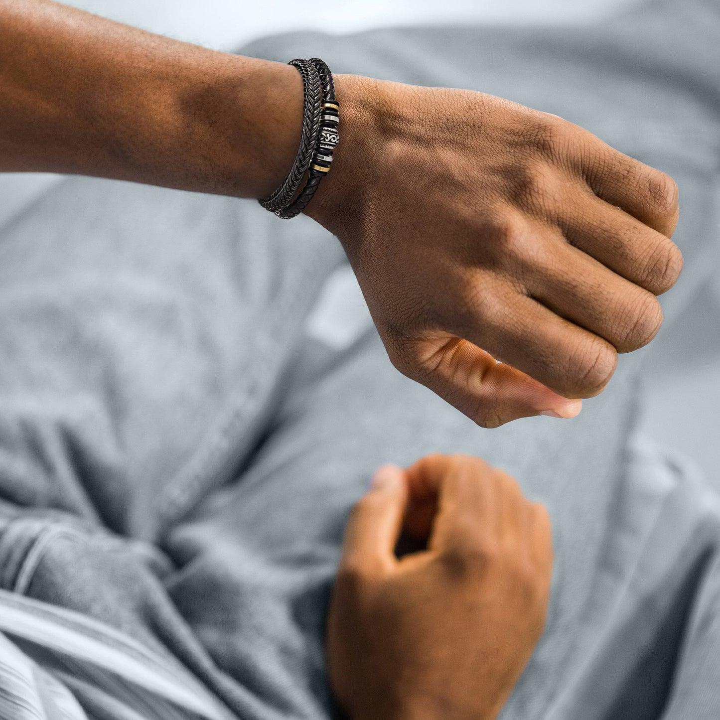 Men's multi-strand bracelet featuring a layered design with intricate details, worn on the wrist to showcase its modern and stylish appearance.