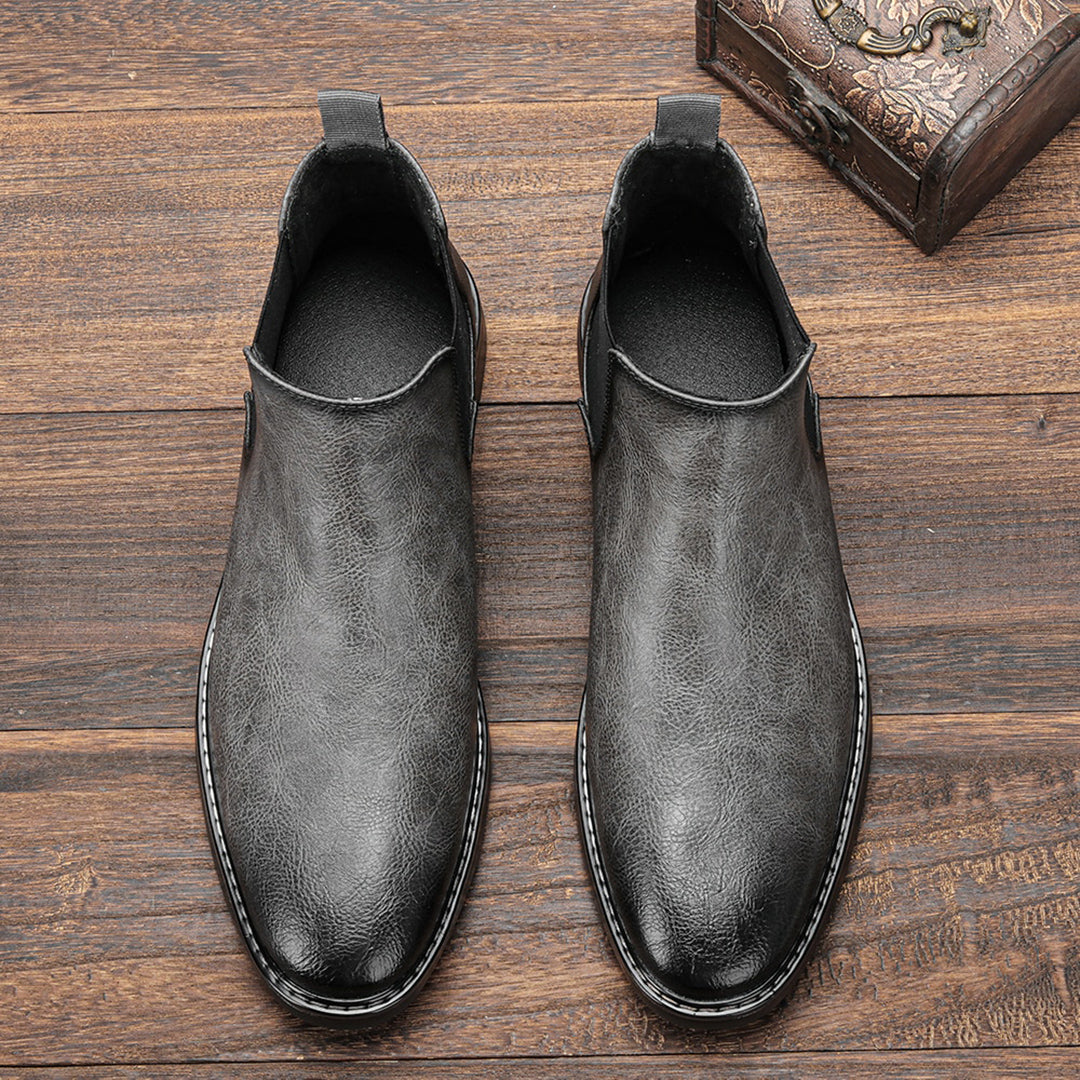 Men's ankle boots with a sleek design and durable construction, featuring a pull-tab and sturdy sole, perfect for versatile everyday wear.