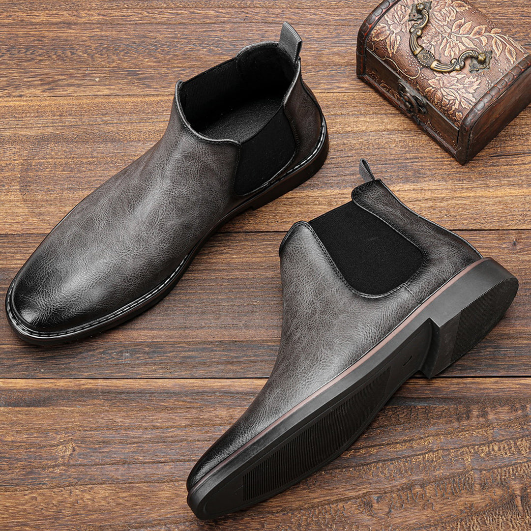 Men's ankle boots with a sleek design and durable construction, featuring a pull-tab and sturdy sole, perfect for versatile everyday wear.