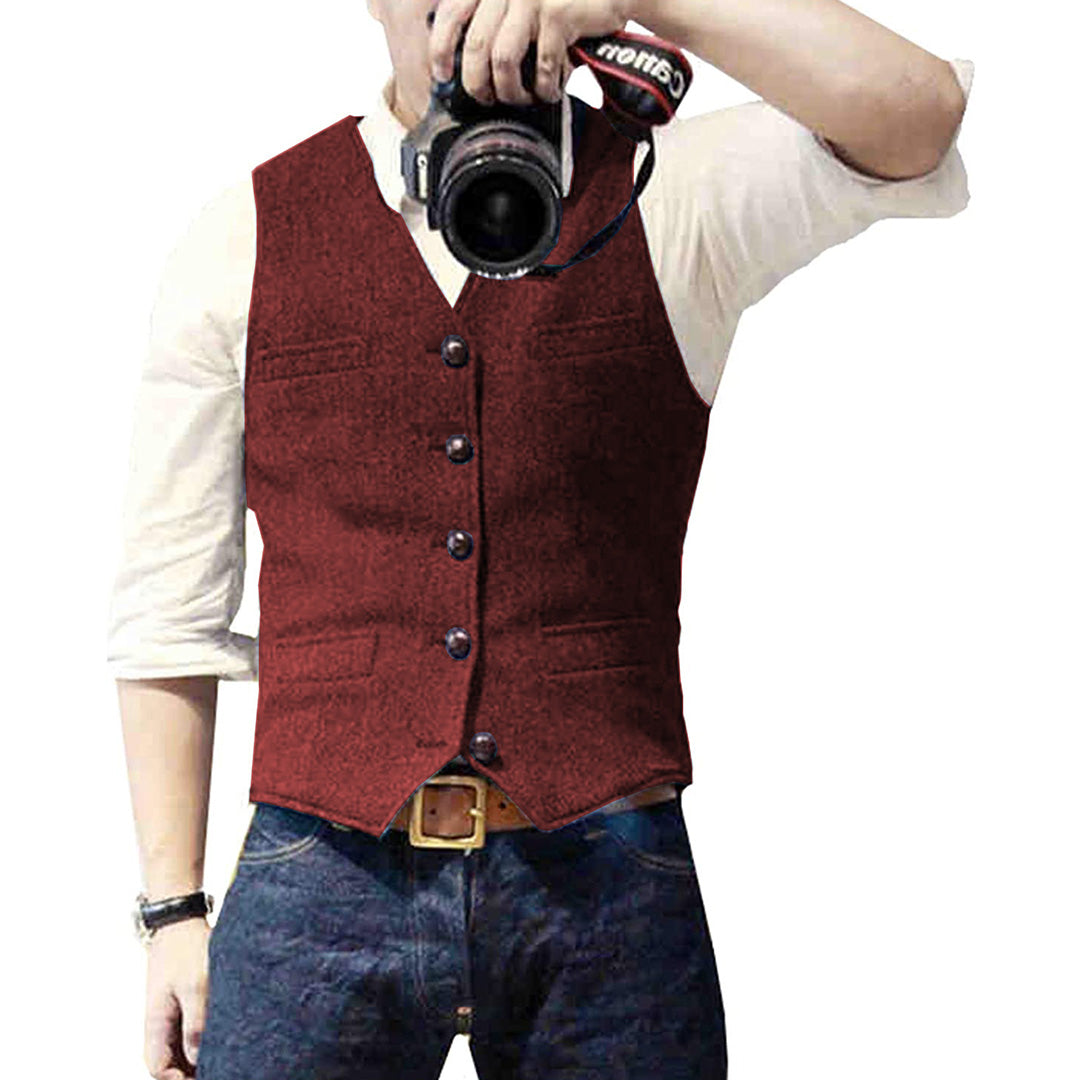 Man wearing a tailored vest paired with a shirt and jeans, holding a camera, showcasing a classic and versatile outfit.