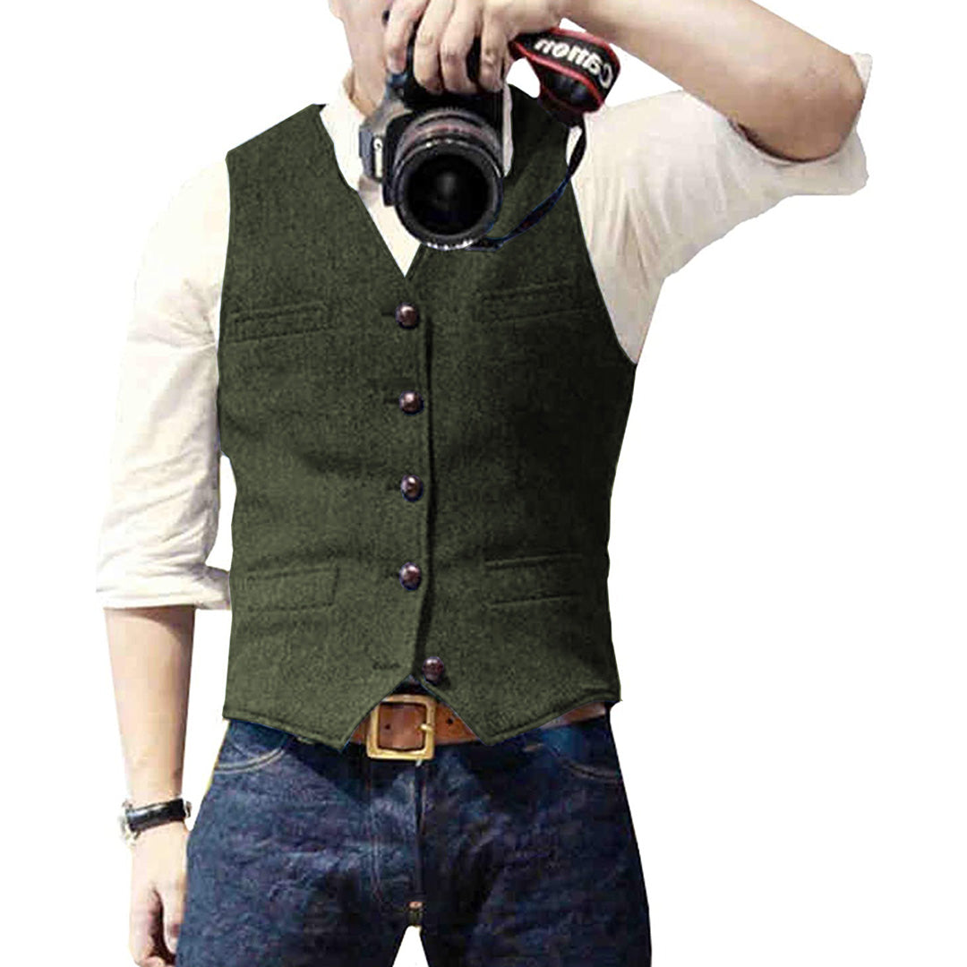 Man wearing a tailored vest paired with a shirt and jeans, holding a camera, showcasing a classic and versatile outfit.