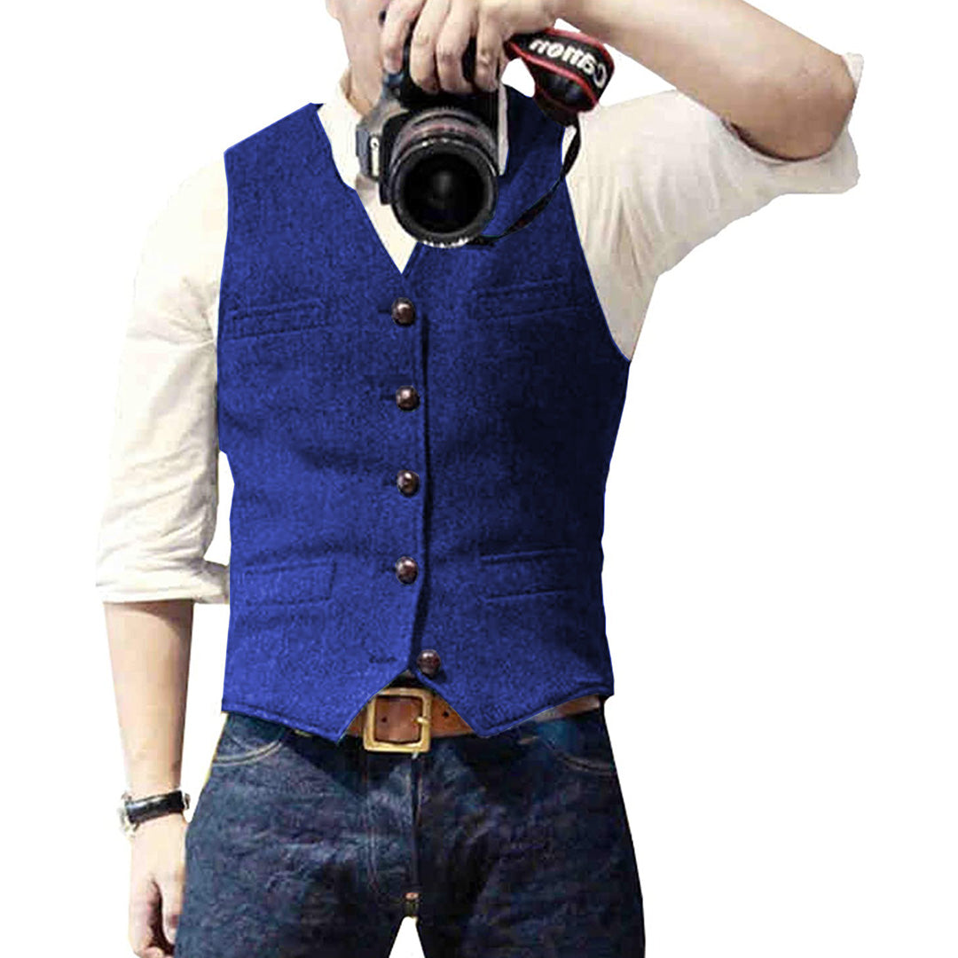 Man wearing a tailored vest paired with a shirt and jeans, holding a camera, showcasing a classic and versatile outfit.