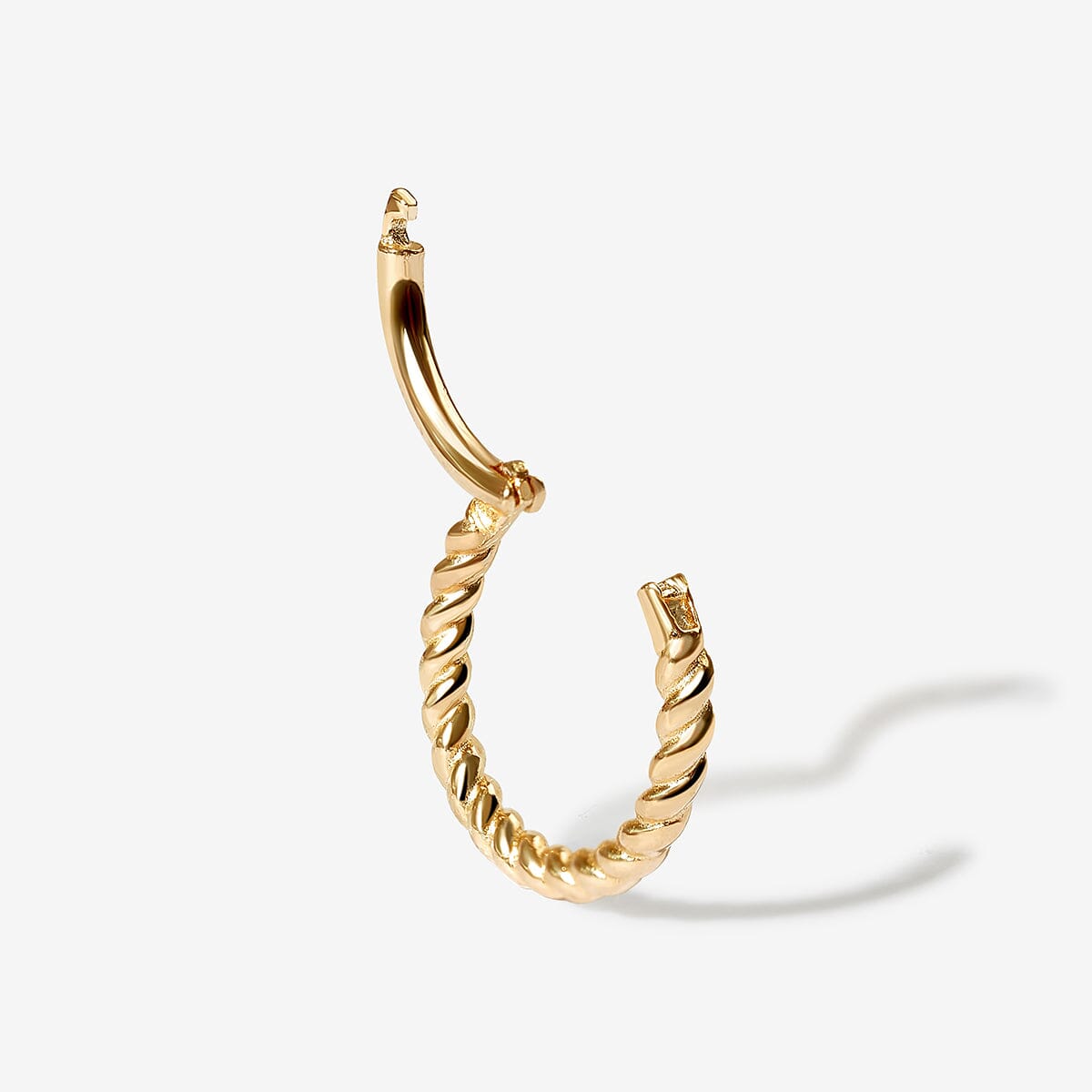 Close-up of a delicate earring set displayed on an ear, showcasing multiple elegant designs with a modern and sophisticated look.