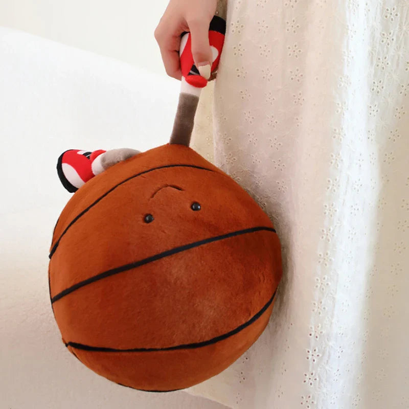 Two playful plush toys designed as cheerful companions, featuring unique sports-inspired designs with smiling faces, seated on a cozy surface.