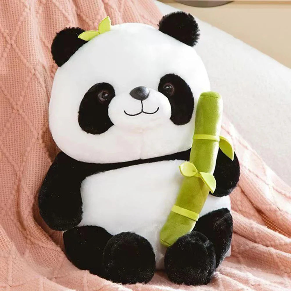 Plush panda toy set featuring a cute panda holding a bamboo and an adorable smiling roll-shaped plush companion, displayed on a table with books in the background.