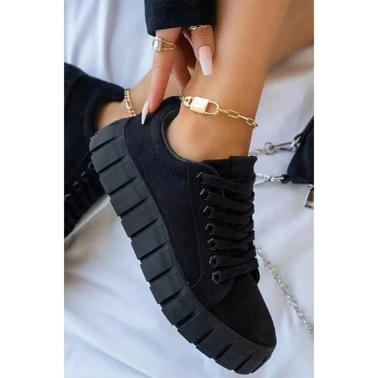 A stylish pair of women's chunky sole sneakers featuring a modern design, held in hand to showcase the bold sole and sleek details, perfect for casual or athleisure wear.