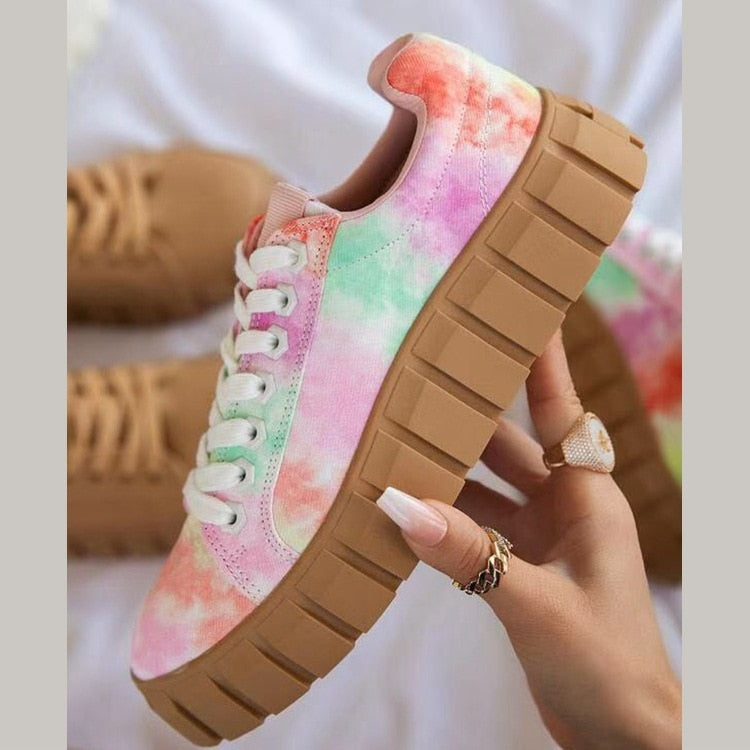 A stylish pair of women's chunky sole sneakers featuring a modern design, held in hand to showcase the bold sole and sleek details, perfect for casual or athleisure wear.