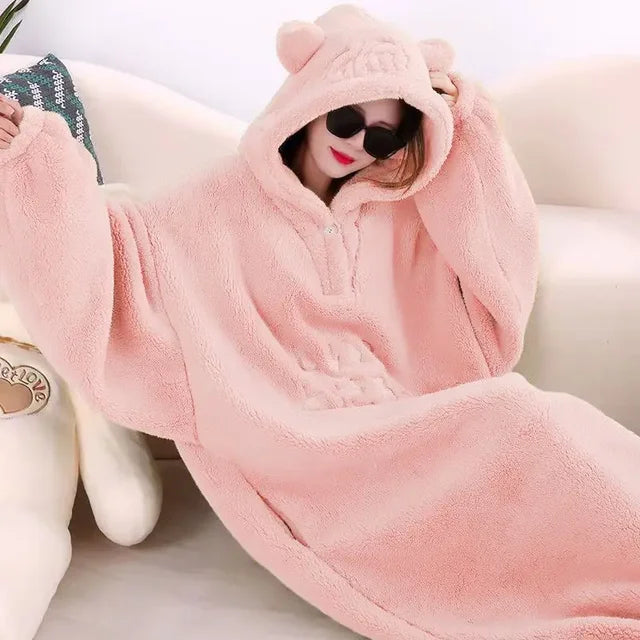 A cozy hooded blanket with an oversized design, featuring soft plush material and playful ear details on the hood, perfect for lounging at home and staying warm in style.