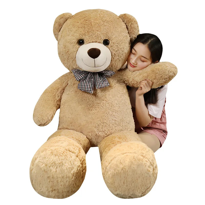 A giant plush bear with a huggable design, featuring soft fabric and an adorable bow, perfect for cuddles, decoration, or as a thoughtful gift for all ages.