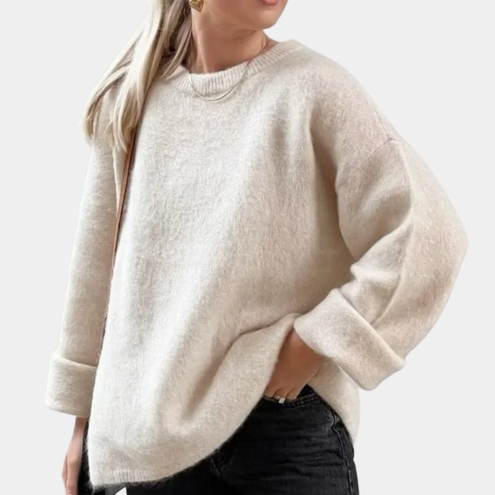 Side view of a woman wearing a relaxed fit knit sweater paired with shorts, showcasing the comfortable and cozy design of the sweater.