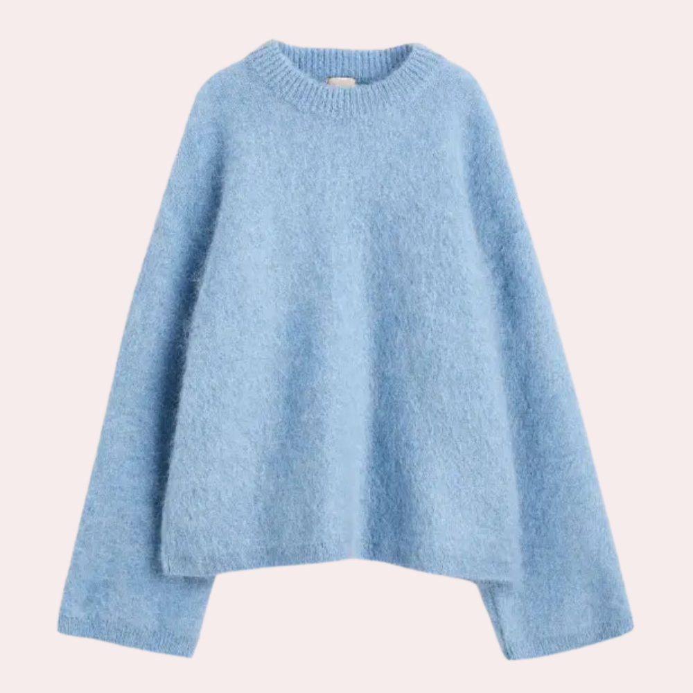 Side view of a woman wearing a relaxed fit knit sweater paired with shorts, showcasing the comfortable and cozy design of the sweater.