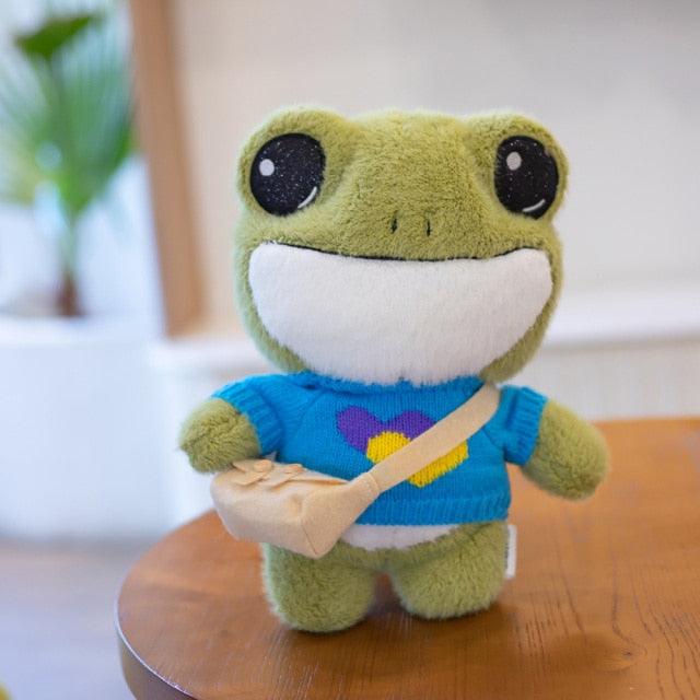Adorable plush frog toy with a charming design, featuring a small bag and decorative details, placed on a wooden surface.