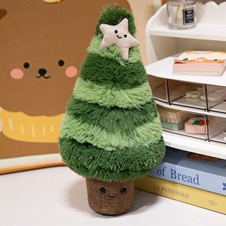 A plush tree decoration with a star on top, designed for festive home decor, placed on a wooden table near a minimalist calendar and decorative frame.