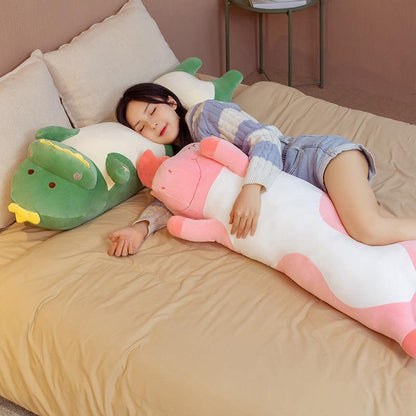A plush body pillow featuring a playful dinosaur design, with a soft and huggable texture, perfect for snuggling, decorating, or gifting to all ages.