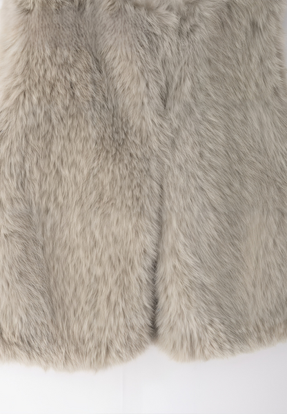 A stylish woman wearing a fluffy vest paired with a turtleneck top and a skirt, showcasing the elegant design and cozy texture of the Ava Women's Fluffy Vest, ideal for layering in chic outfits.