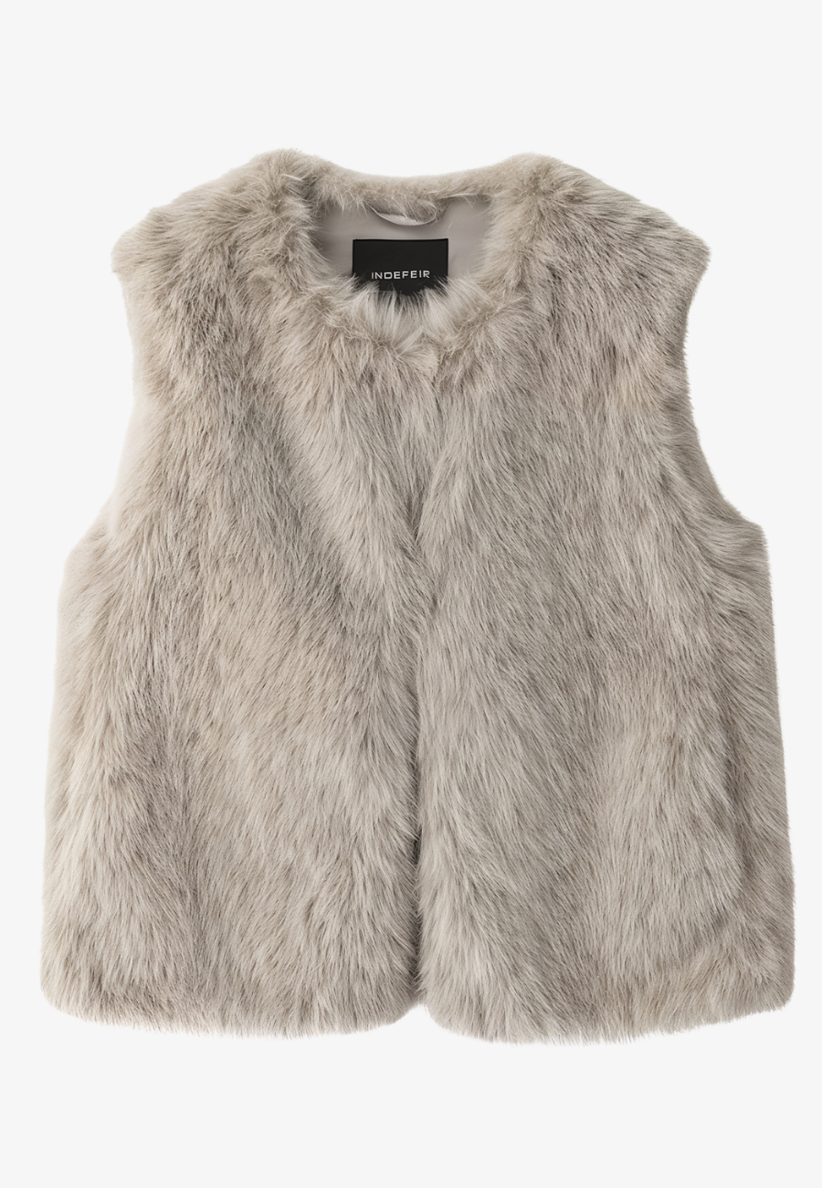 A stylish woman wearing a fluffy vest paired with a turtleneck top and a skirt, showcasing the elegant design and cozy texture of the Ava Women's Fluffy Vest, ideal for layering in chic outfits.
