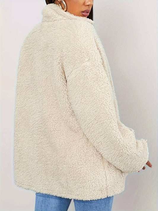 A stylish women's sherpa jacket with a cozy oversized fit, featuring button closures, large front pockets, and a soft textured design, paired with casual jeans and a printed t-shirt for a trendy look.