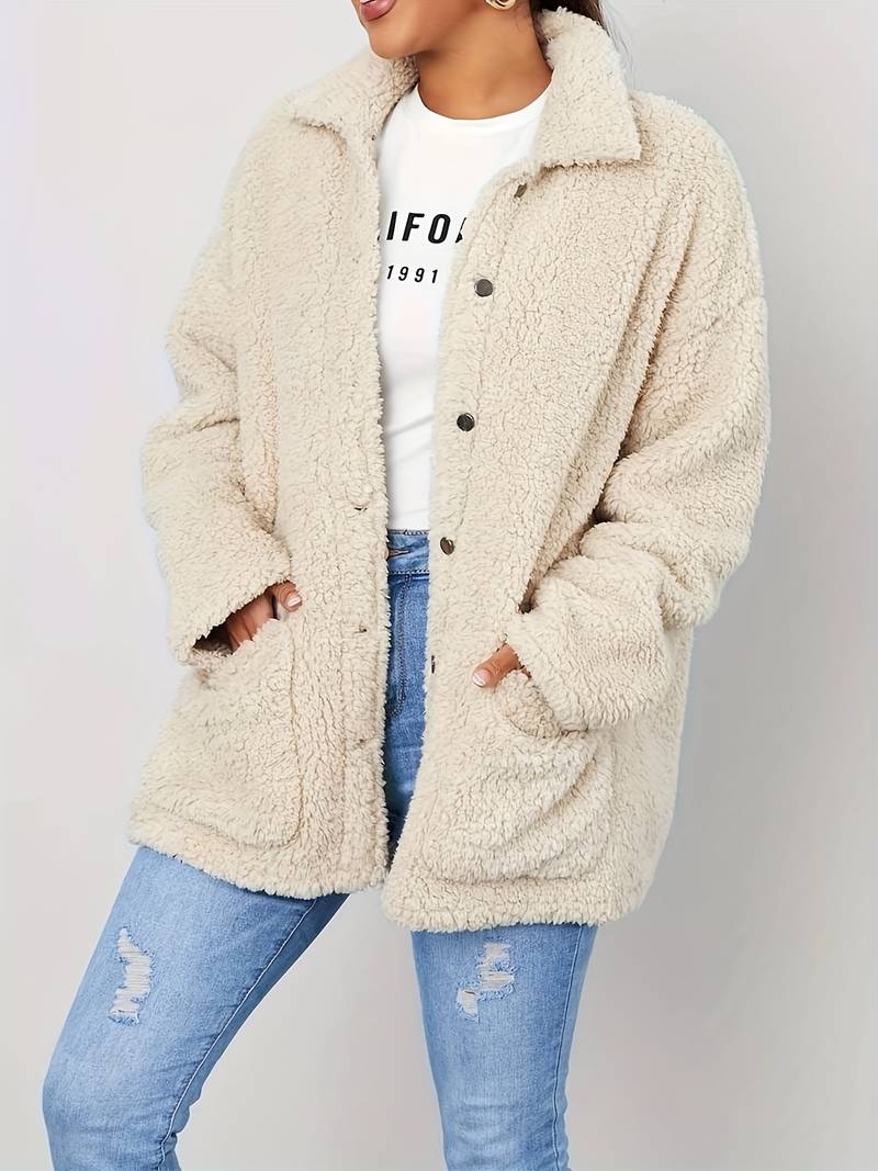 A stylish women's sherpa jacket with a cozy oversized fit, featuring button closures, large front pockets, and a soft textured design, paired with casual jeans and a printed t-shirt for a trendy look.