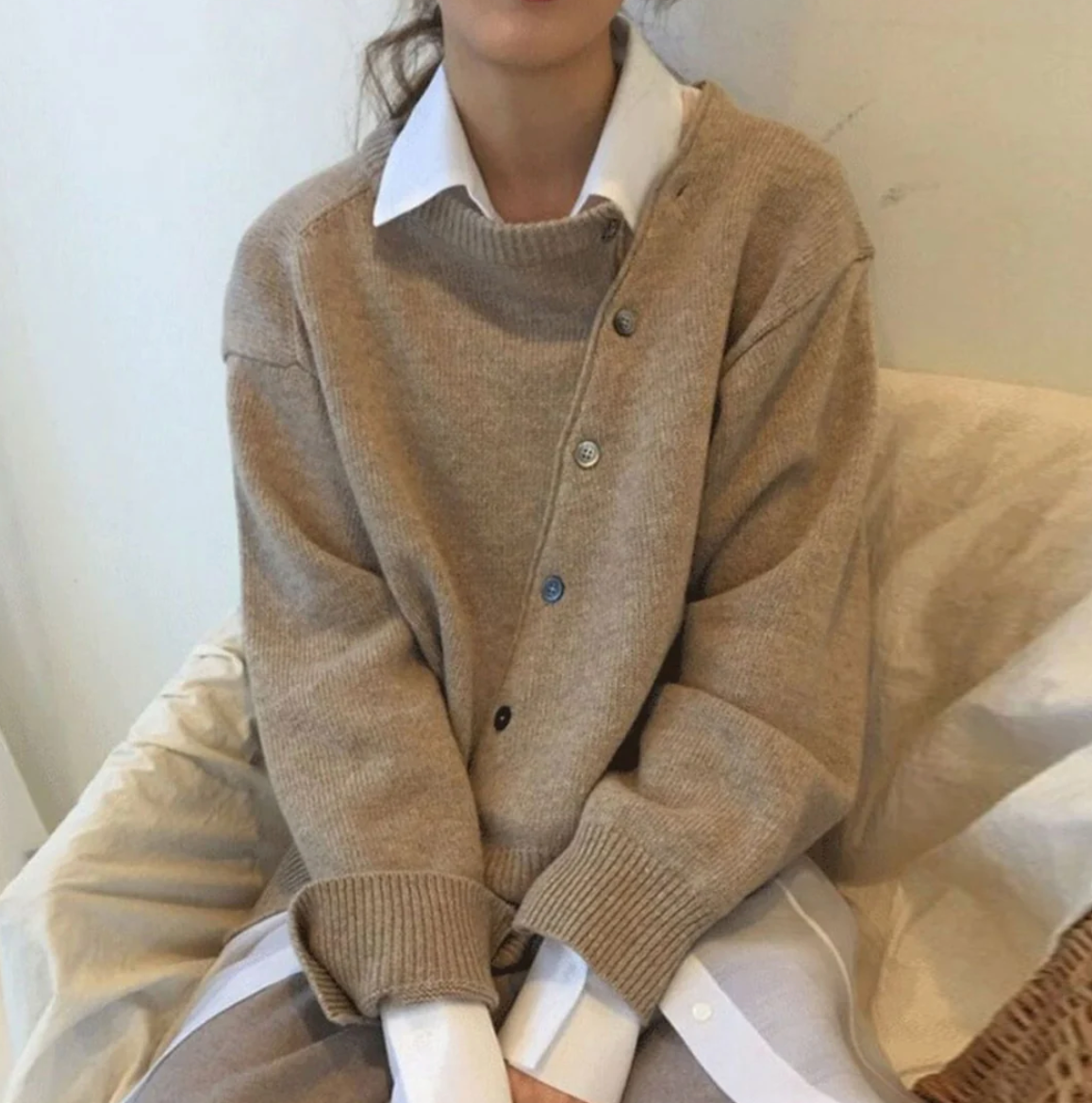 A stylish asymmetrical women's cardigan with button details and an elegant, modern design, suitable for casual or formal wear.