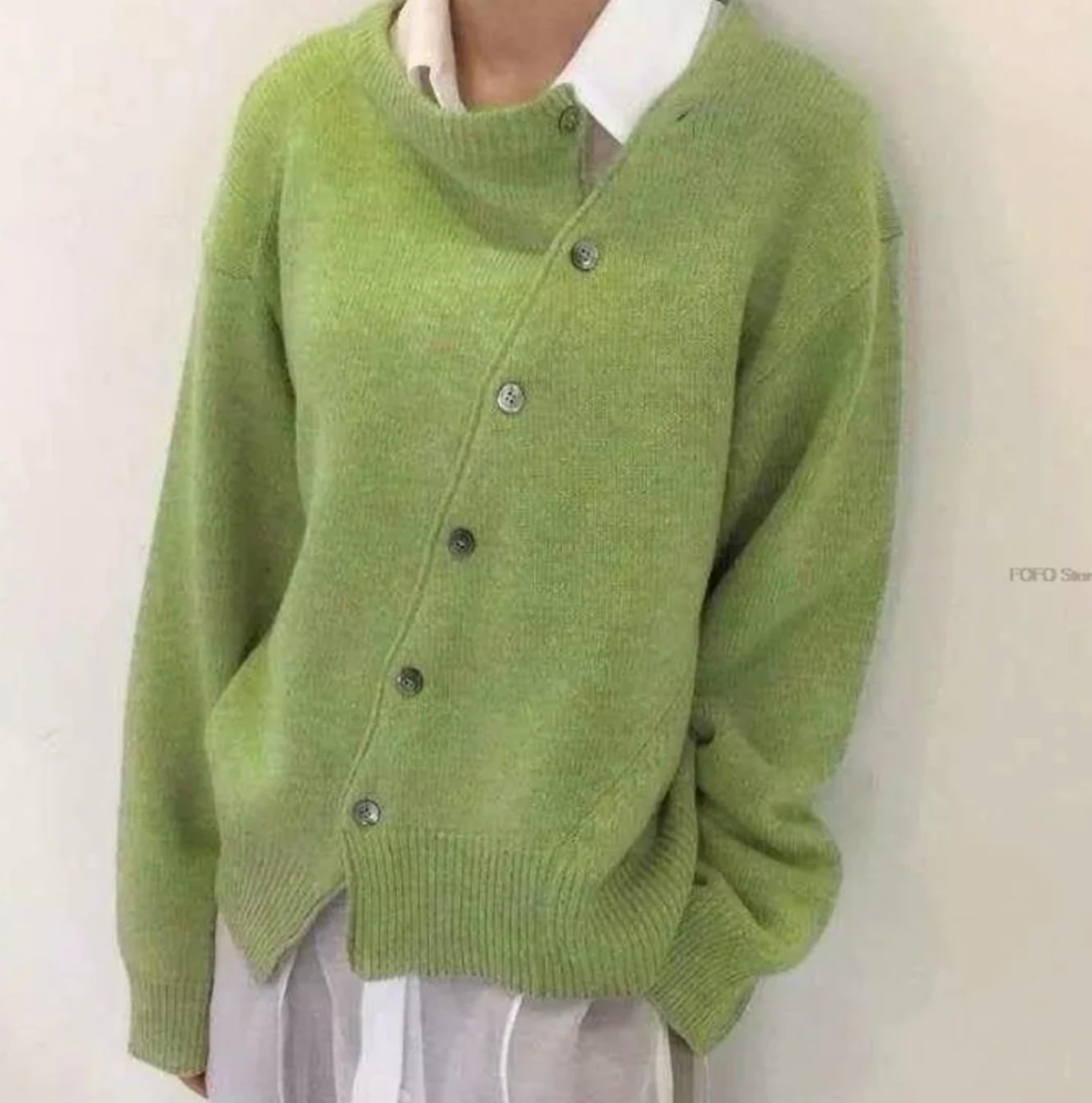 A stylish asymmetrical women's cardigan with button details and an elegant, modern design, suitable for casual or formal wear.