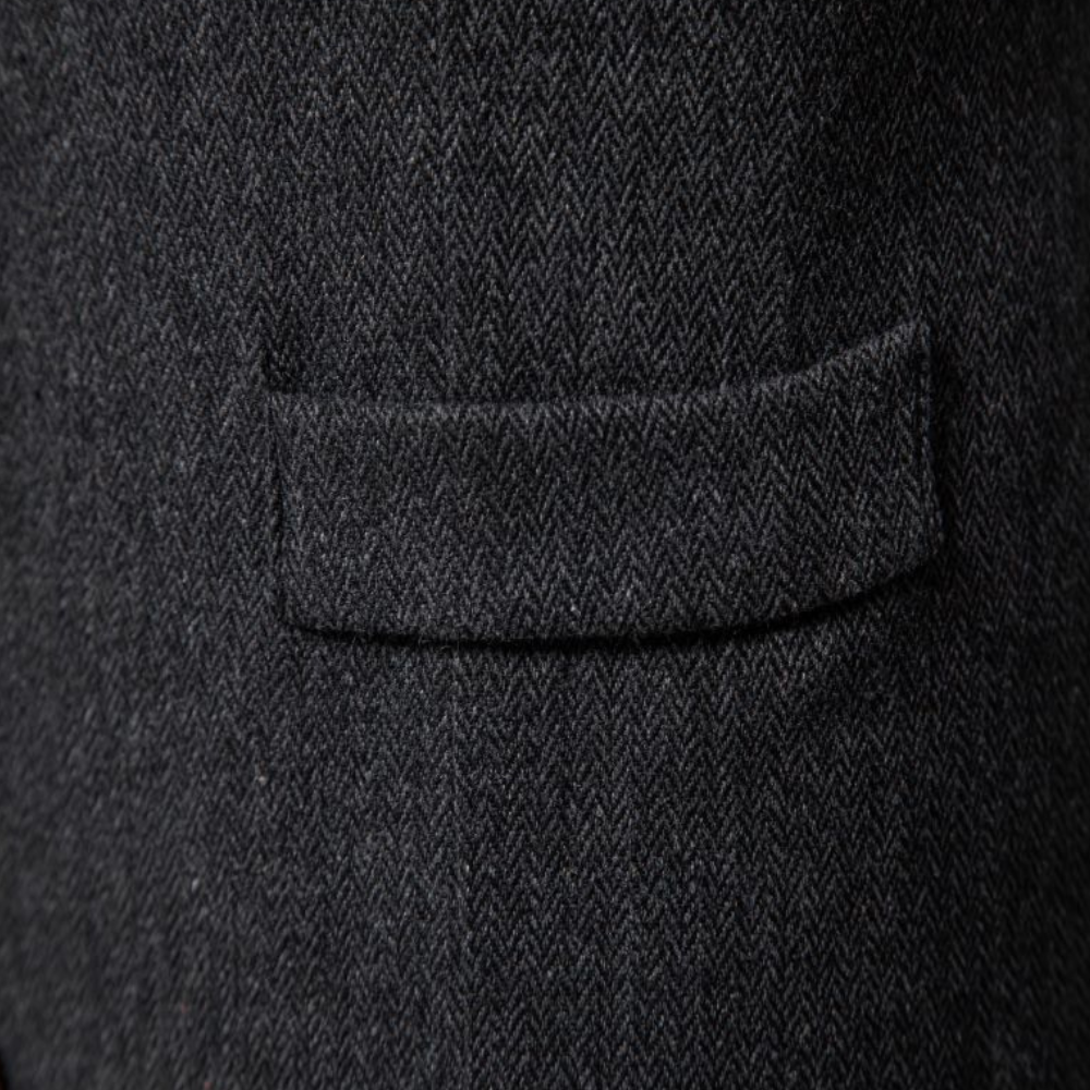 Man wearing a tailored vest paired with a shirt and jeans, holding a camera, showcasing a classic and versatile outfit.