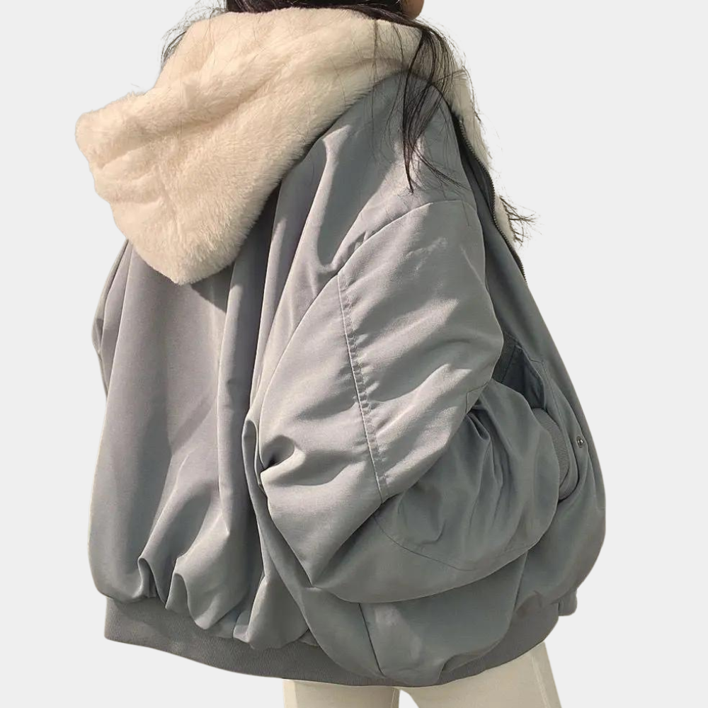 A woman wearing a cozy winter jacket with a soft and elegant design, featuring a comfortable fit and stylish details, perfect for staying warm during chilly days.