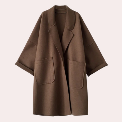 Stylish oversized women's coat with a relaxed fit, featuring deep pockets and a cozy design, worn by a model holding a cup while walking gracefully.