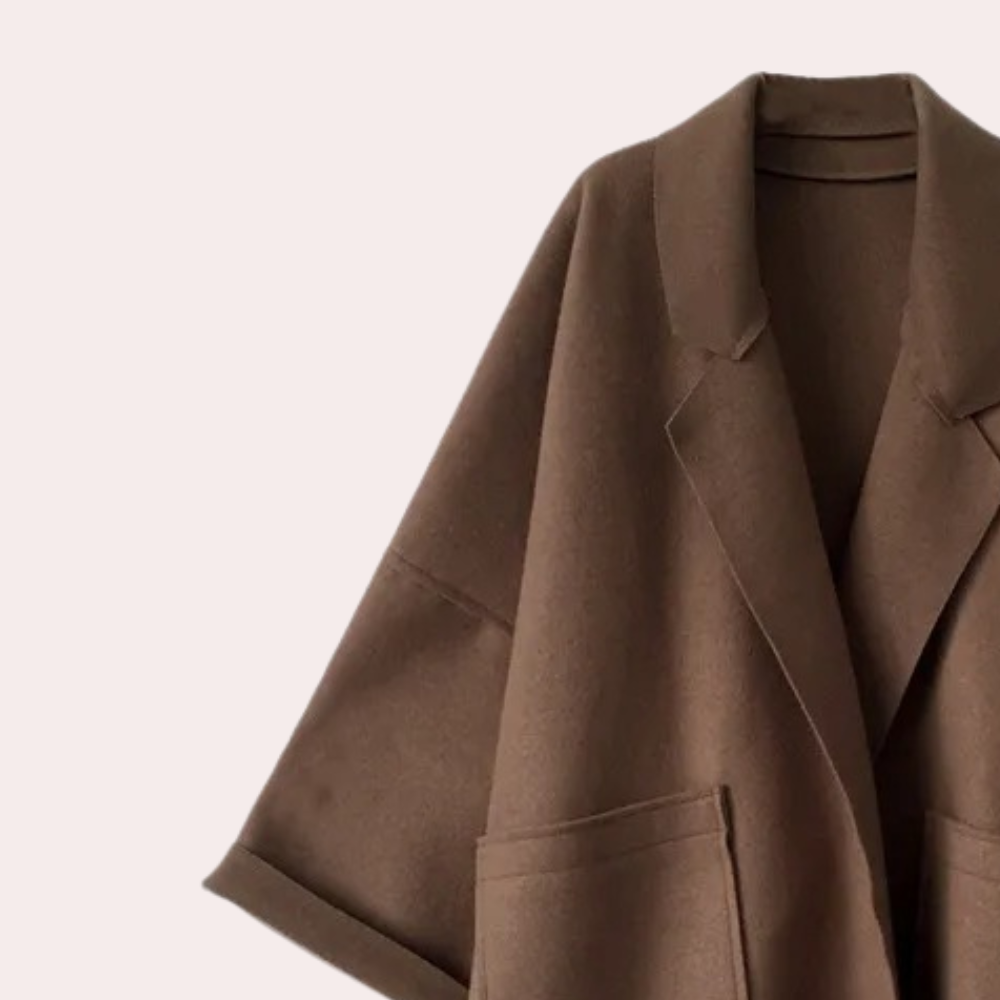 Stylish oversized women's coat with a relaxed fit, featuring deep pockets and a cozy design, worn by a model holding a cup while walking gracefully.