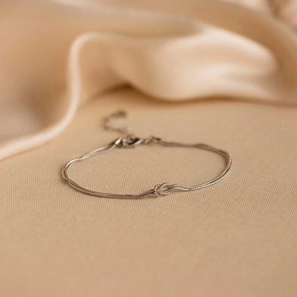 Minimalist bracelet with a sleek design displayed on a wrist, showcasing its elegant and timeless style in a cozy setting.
