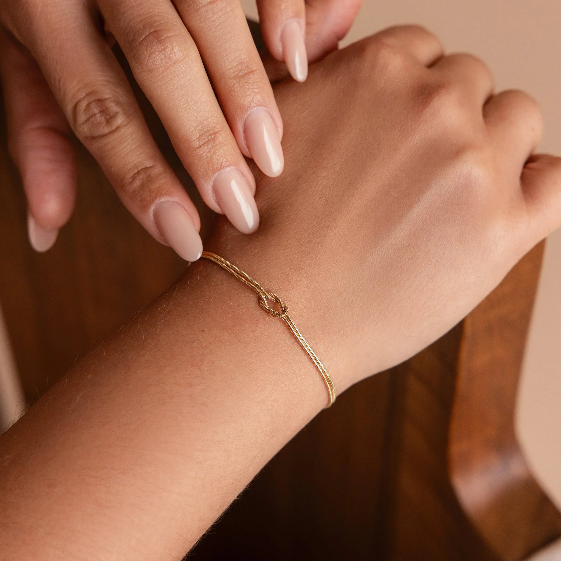 Minimalist bracelet with a sleek design displayed on a wrist, showcasing its elegant and timeless style in a cozy setting.