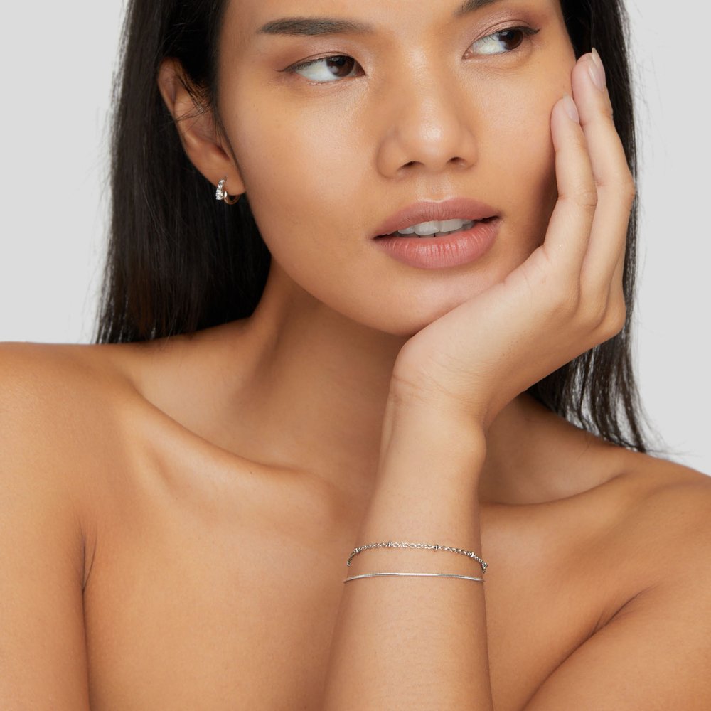 Minimalist bracelet set displayed on a woman's wrist, complementing her elegant and sophisticated look with a timeless design.