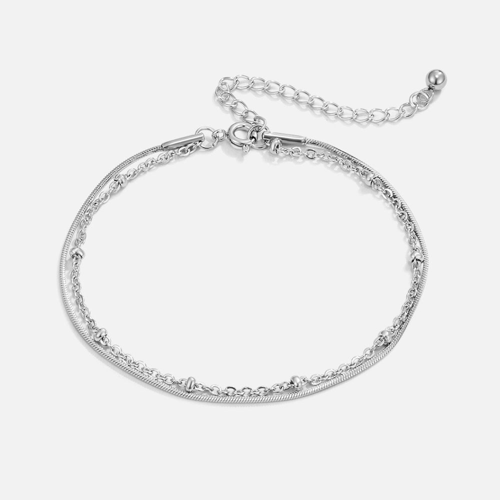 Minimalist bracelet set displayed on a woman's wrist, complementing her elegant and sophisticated look with a timeless design.