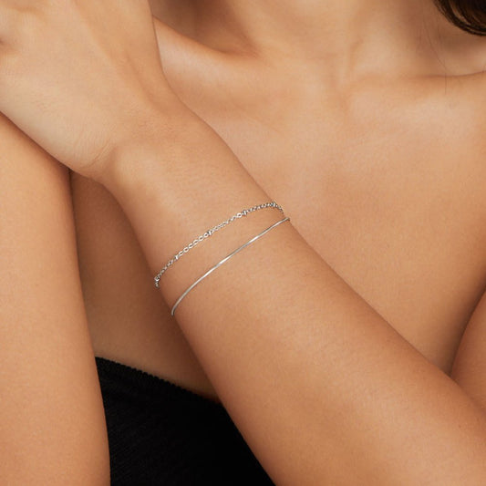Minimalist bracelet set displayed on a woman's wrist, complementing her elegant and sophisticated look with a timeless design.