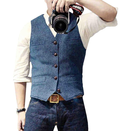 Man wearing a tailored vest paired with a shirt and jeans, holding a camera, showcasing a classic and versatile outfit.