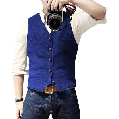 Man wearing a tailored vest paired with a shirt and jeans, holding a camera, showcasing a classic and versatile outfit.