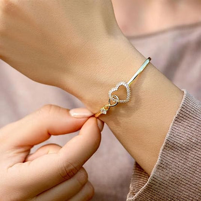 Elegant bracelet with a heart-shaped design and sparkling accents, worn on a wrist to highlight its sophisticated and timeless charm.